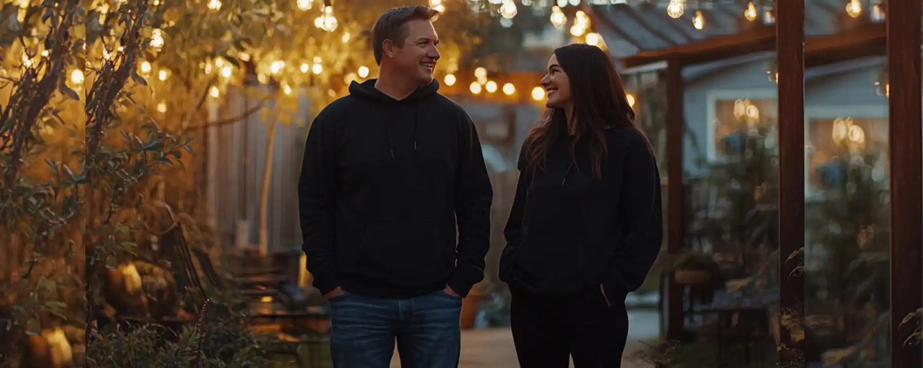 A couple walking together at dusk wearing dark sweaters.