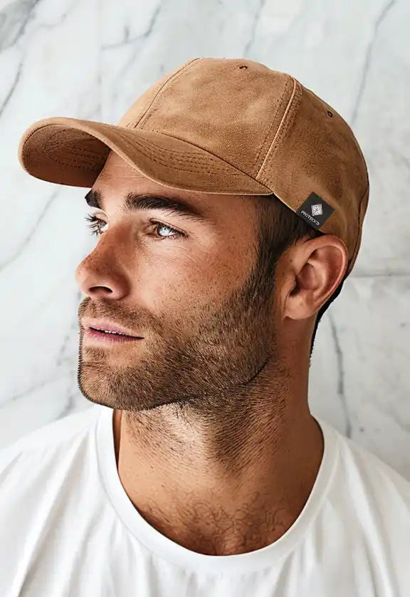 Tan suede baseball cap worn at a side profile angle.